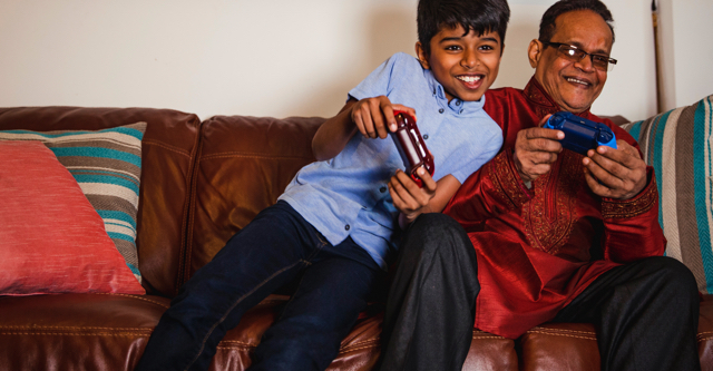 grandson and grandfather playing game console