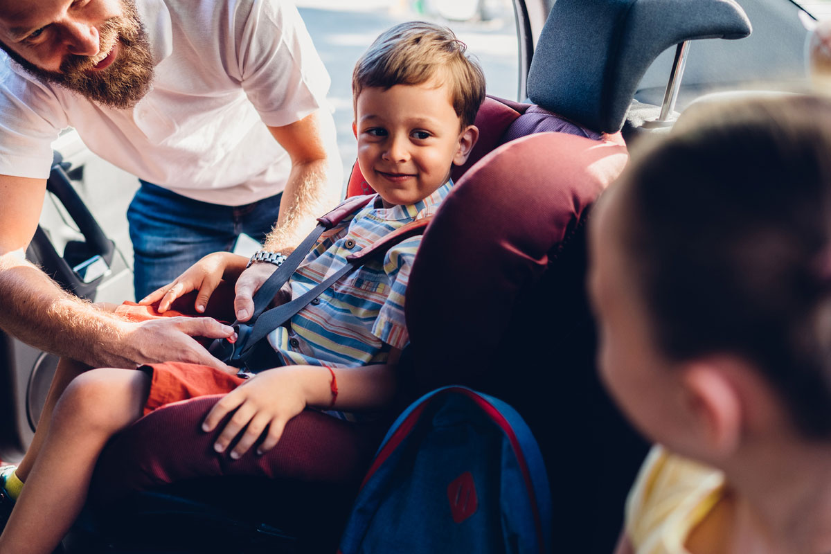 Man-closing-child-s-seatbelt