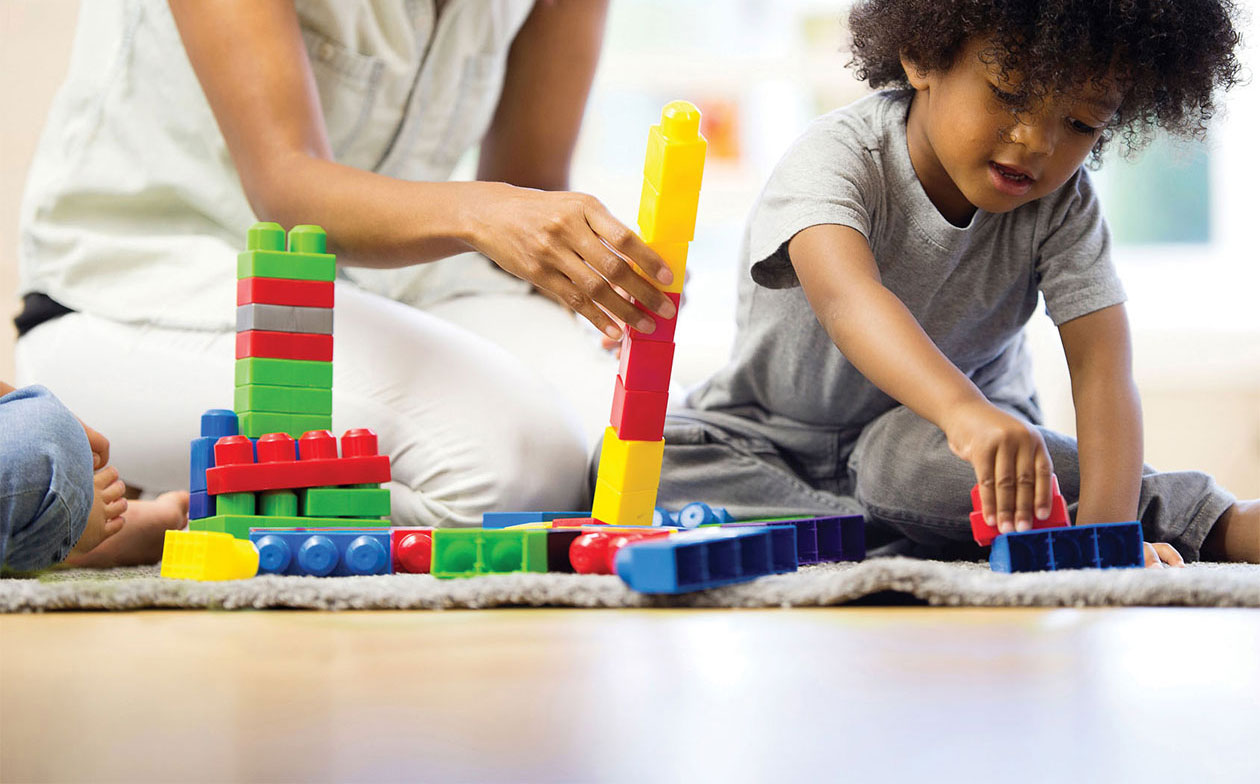 woman and children playing with building blocks