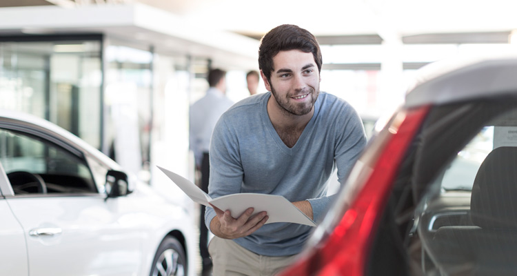 Man looking at a car in a showroom.